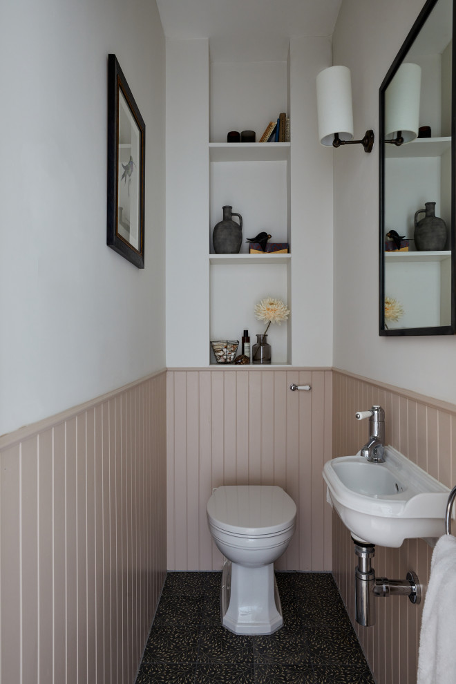 ロンドンにあるトラディショナルスタイルのおしゃれなトイレ・洗面所 (ピンクの壁、磁器タイルの床、壁付け型シンク、青い床、フローティング洗面台) の写真