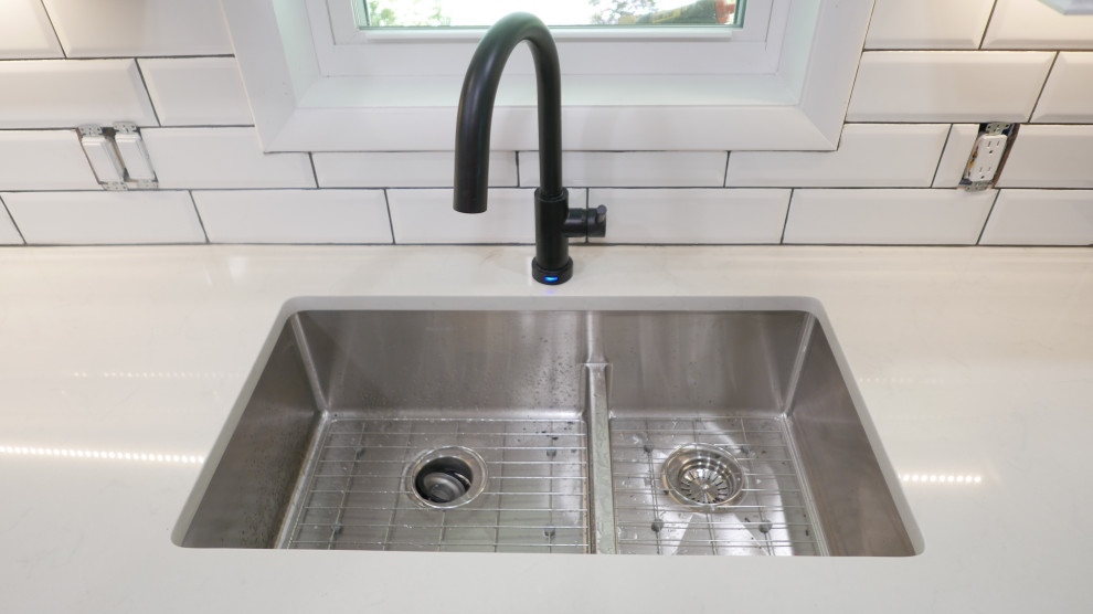 Mid-sized transitional galley porcelain tile and gray floor eat-in kitchen photo with an undermount sink, shaker cabinets, white cabinets, quartz countertops, white backsplash, subway tile backsplash, black appliances, no island and white countertops