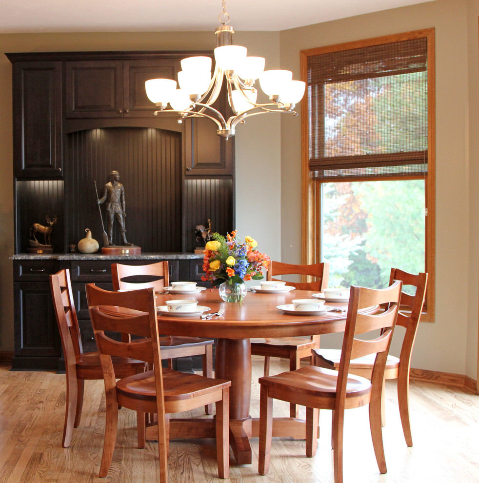 This is an example of a mid-sized traditional kitchen/dining combo in Milwaukee with beige walls, medium hardwood floors and brown floor.