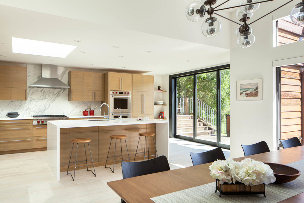 Contemporary eat-in kitchen in San Francisco with an undermount sink, flat-panel cabinets, medium wood cabinets, white splashback, stone slab splashback, stainless steel appliances, with island, white floor and white benchtop.