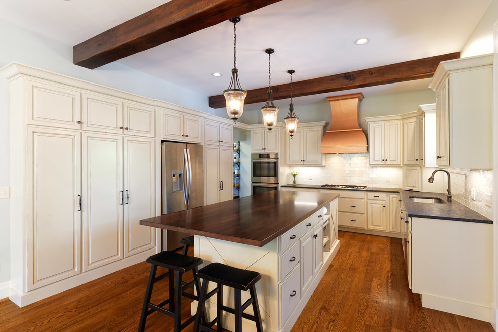 Inspiration for a traditional kitchen in Cincinnati with a drop-in sink, raised-panel cabinets, distressed cabinets, granite benchtops, subway tile splashback, stainless steel appliances, medium hardwood floors and with island.