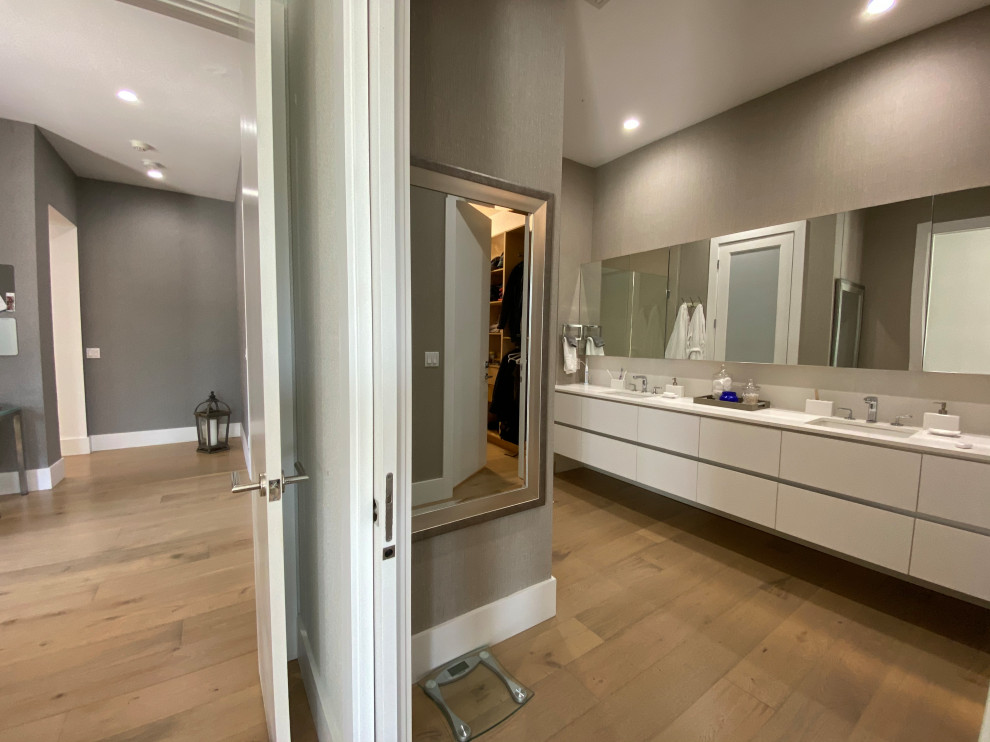 Large modern kids bathroom in Miami with flat-panel cabinets, white cabinets, a one-piece toilet, gray tile, porcelain tile, white walls, light hardwood floors, an undermount sink, quartzite benchtops, grey floor, a hinged shower door, white benchtops, a double vanity and a floating vanity.