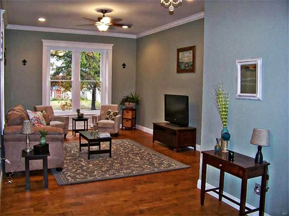 Small traditional formal open concept living room in St Louis with blue walls, dark hardwood floors, no fireplace and a wall-mounted tv.