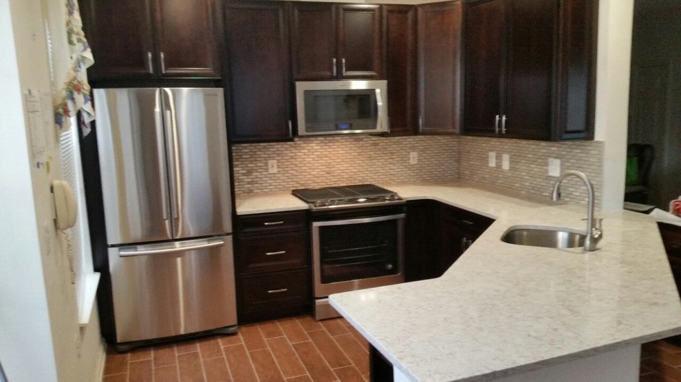 Mid-sized transitional l-shaped laminate floor and brown floor enclosed kitchen photo in DC Metro with an undermount sink, recessed-panel cabinets, dark wood cabinets, quartzite countertops, white backsplash, mosaic tile backsplash, stainless steel appliances, a peninsula and white countertops