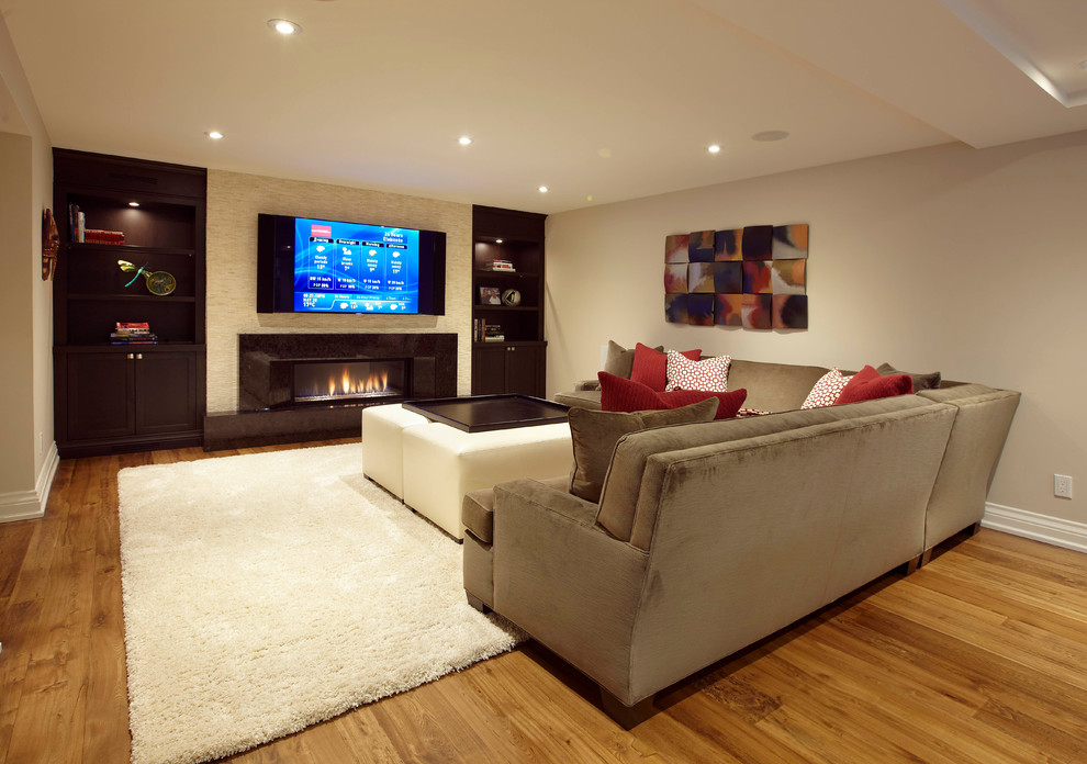 Inspiration for a mid-sized transitional walk-out basement in Toronto with medium hardwood floors, a ribbon fireplace and a tile fireplace surround.