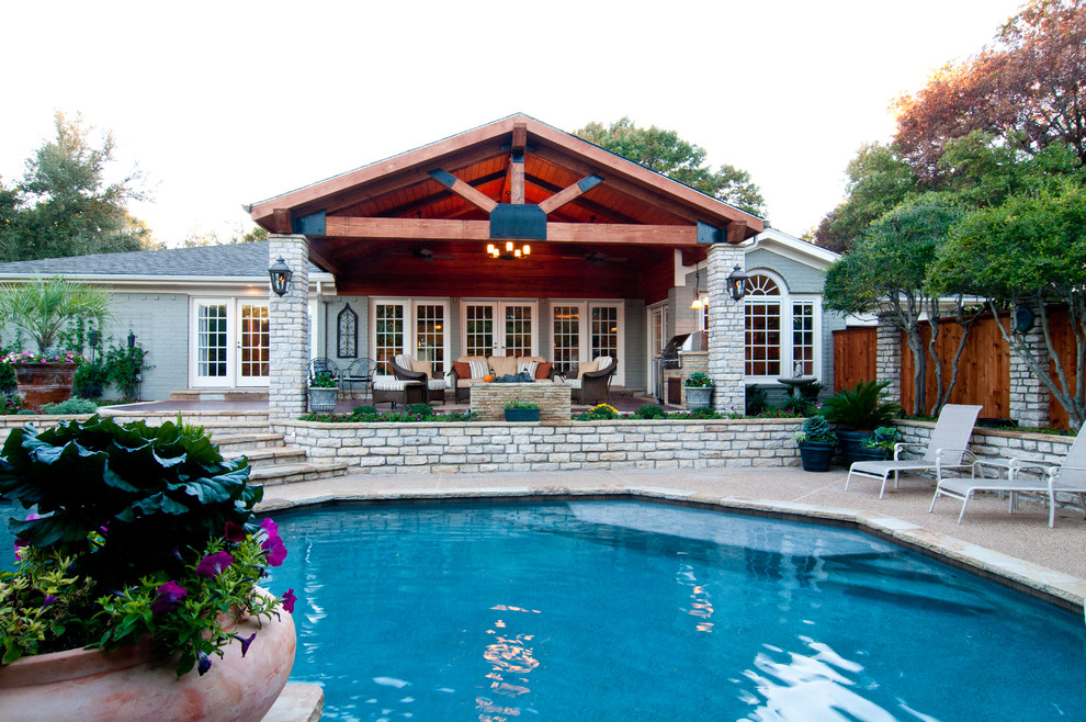 Design ideas for a large modern backyard custom-shaped lap pool in Dallas with a water feature and concrete slab.