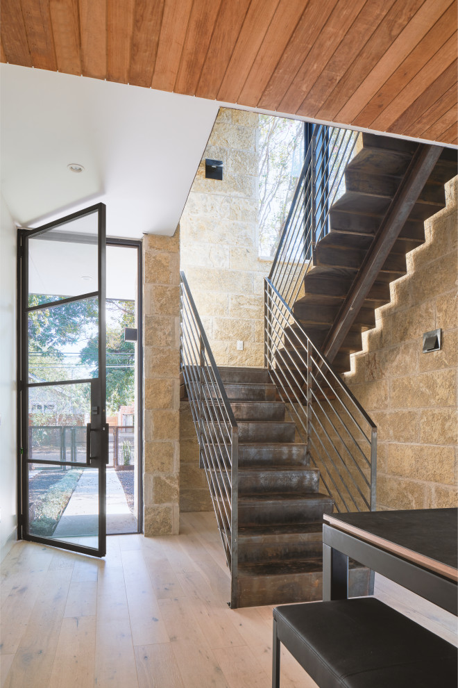 Photo of a large contemporary metal u-shaped staircase in Austin with metal risers and metal railing.
