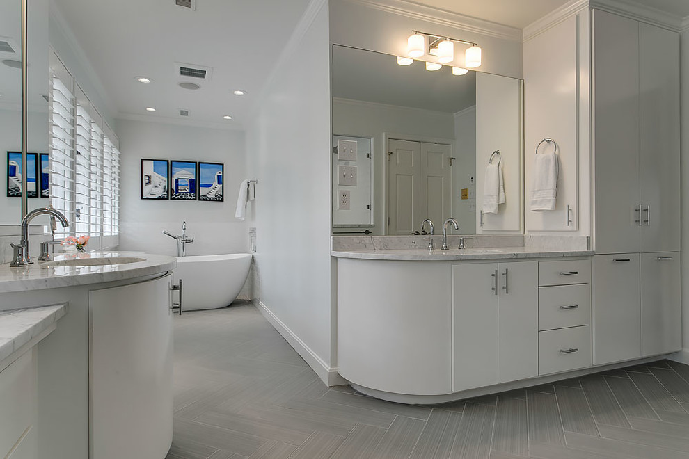 Freestanding bathtub - transitional gray tile ceramic tile freestanding bathtub idea in Raleigh with flat-panel cabinets, white cabinets, an undermount sink and marble countertops
