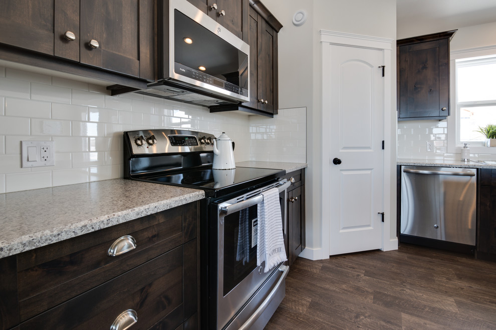 Mid-sized transitional l-shaped open concept kitchen photo with shaker cabinets, dark wood cabinets, laminate countertops, stainless steel appliances and an island