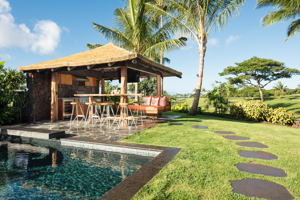 Inspiration for a large tropical backyard patio in Hawaii with an outdoor kitchen, natural stone pavers and a gazebo/cabana.