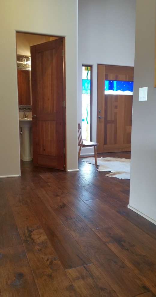 This is an example of a large contemporary foyer in Phoenix with white walls, dark hardwood floors, a single front door and a medium wood front door.