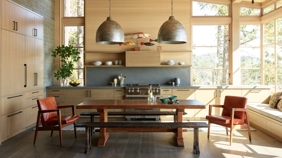 Beach style eat-in kitchen in Seattle with flat-panel cabinets, light wood cabinets, grey splashback, stainless steel appliances, dark hardwood floors, brown floor and grey benchtop.