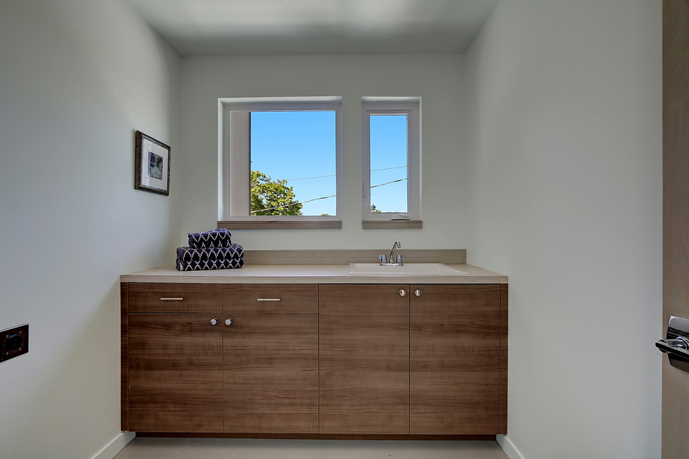 Laundry room - modern laundry room idea in Seattle with a drop-in sink, dark wood cabinets and quartz countertops