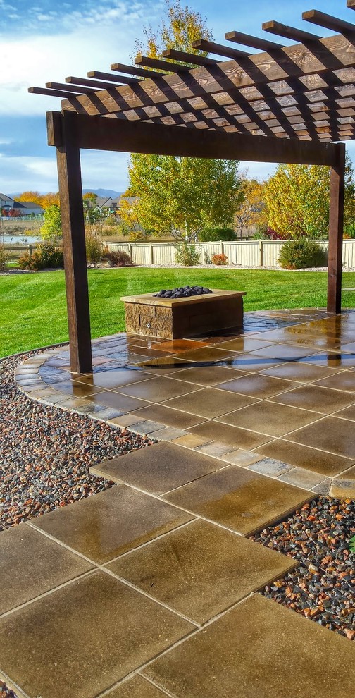 Design ideas for a mid-sized country backyard patio in Denver with a fire feature, natural stone pavers and a pergola.