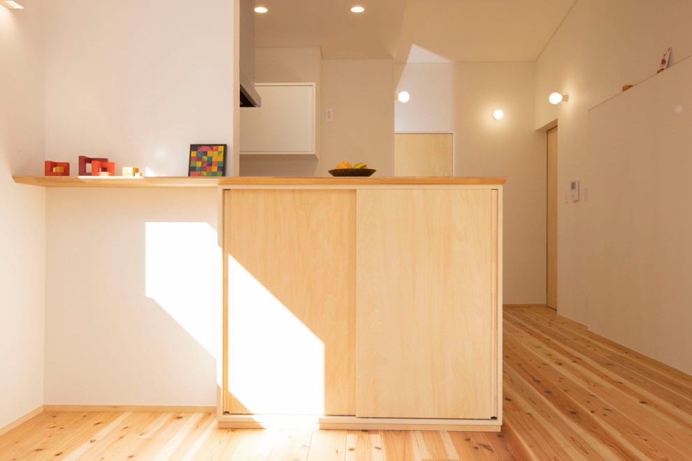 Cette image montre un salon avec un mur blanc, un sol en bois brun, un plafond en papier peint et du papier peint.