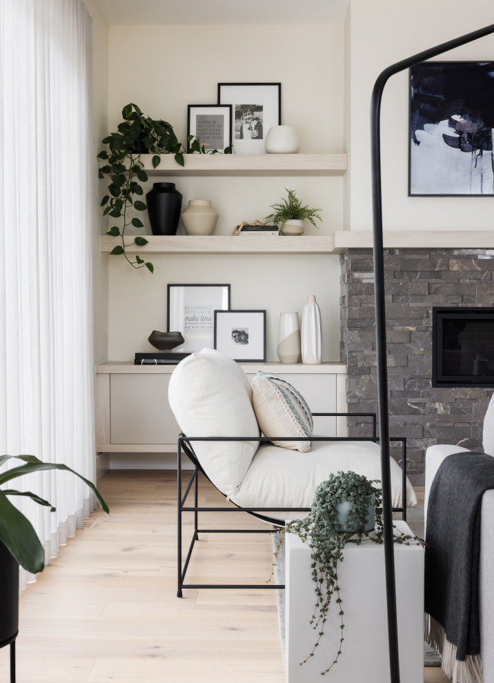 Foto de salón abierto minimalista de tamaño medio con paredes blancas, suelo de madera clara, todas las chimeneas, piedra de revestimiento, televisor colgado en la pared y suelo beige