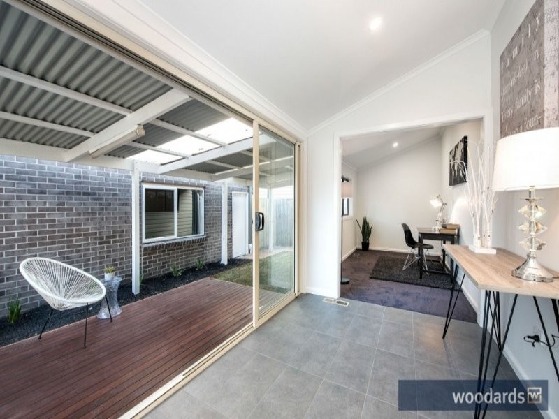 This is an example of a mid-sized contemporary study room in Melbourne with white walls, carpet and a freestanding desk.