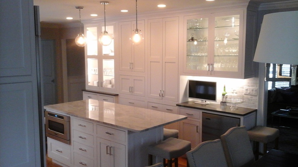 Eat-in kitchen - mid-sized transitional l-shaped light wood floor eat-in kitchen idea in Newark with a double-bowl sink, shaker cabinets, white cabinets, solid surface countertops, multicolored backsplash, stone tile backsplash, stainless steel appliances and an island