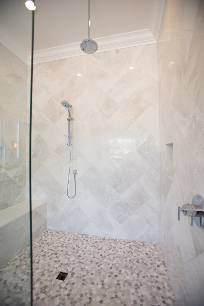 This is an example of a large transitional master bathroom in Phoenix with white cabinets, a freestanding tub, gray tile, grey walls, an undermount sink, recessed-panel cabinets, medium hardwood floors, grey floor, a curbless shower, a one-piece toilet, marble, marble benchtops and a hinged shower door.