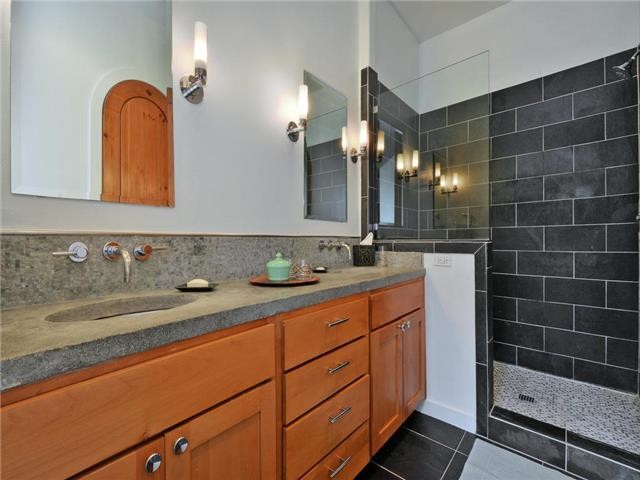 Small contemporary master bathroom in Austin with an undermount sink, recessed-panel cabinets, medium wood cabinets, an alcove shower, black tile, grey walls and ceramic floors.