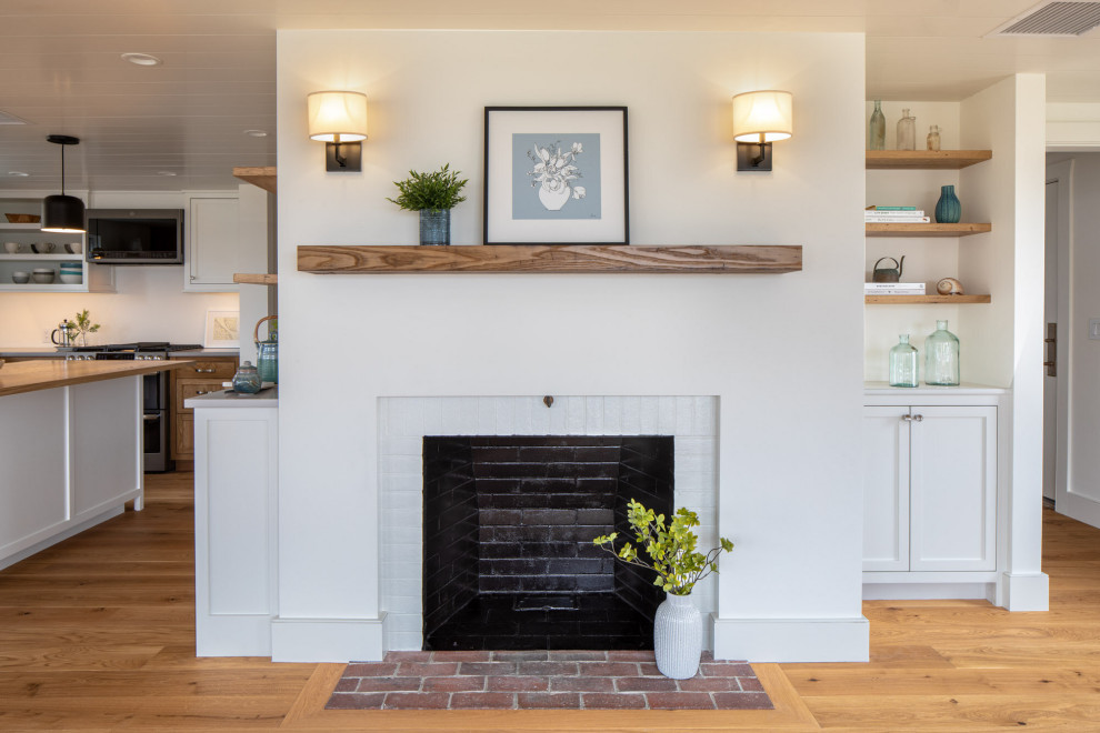 Small beach style open concept living room in Boston with white walls, medium hardwood floors, a standard fireplace, a brick fireplace surround, brown floor and timber.