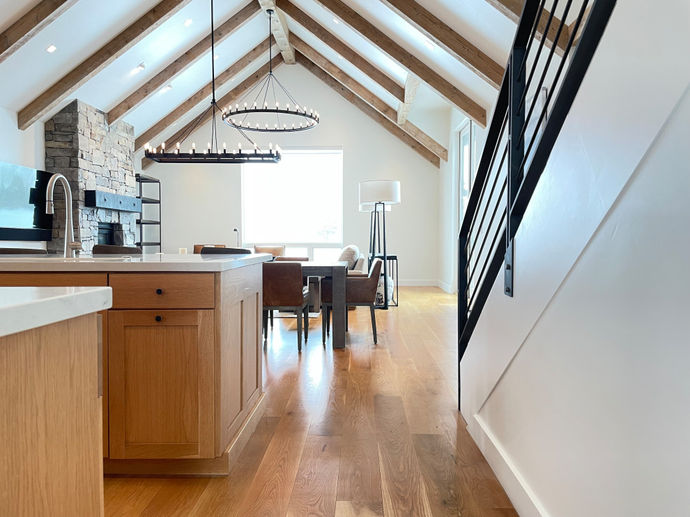 Eat-in kitchen - rustic laminate floor, orange floor and exposed beam eat-in kitchen idea with a single-bowl sink, medium tone wood cabinets, quartz countertops, stainless steel appliances, an island and white countertops