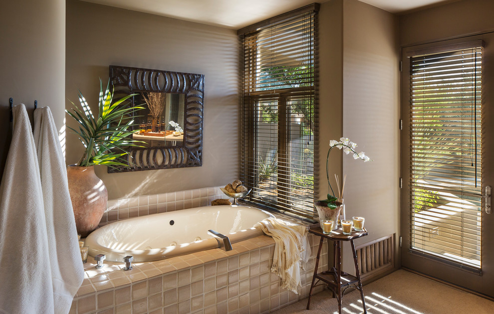 Traditional bathroom in Phoenix with a drop-in tub, beige tile and beige walls.