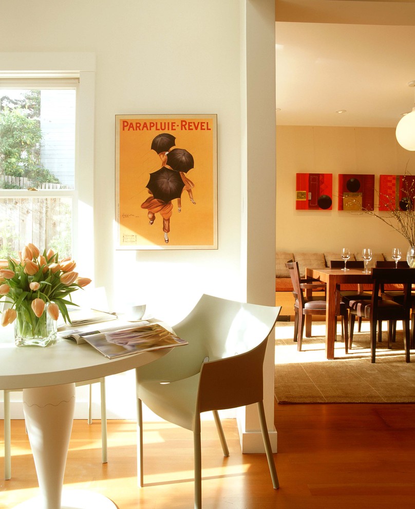 This is an example of a modern dining room in San Francisco with white walls and medium hardwood floors.