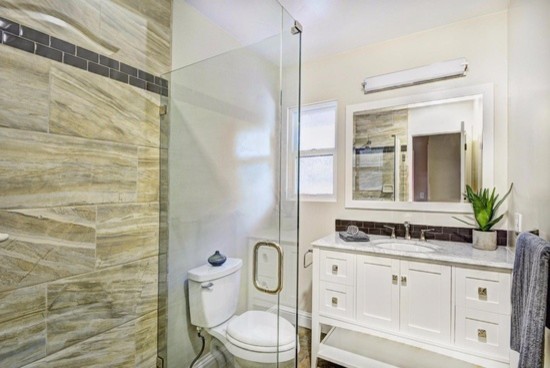 Photo of a transitional bathroom in Other with white cabinets and marble benchtops.