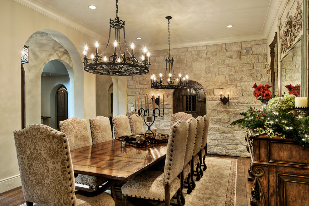 This is an example of a mediterranean dining room in Houston with beige walls, dark hardwood floors and no fireplace.