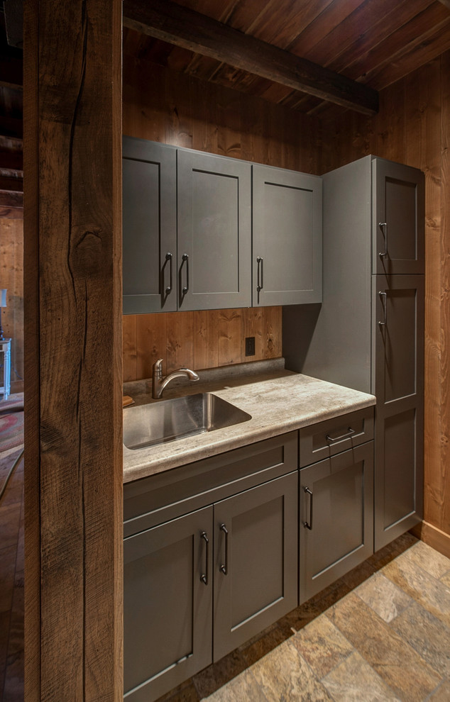 Photo of a mid-sized country single-wall laundry room in Minneapolis with a single-bowl sink, flat-panel cabinets, grey cabinets, laminate benchtops and timber splashback.