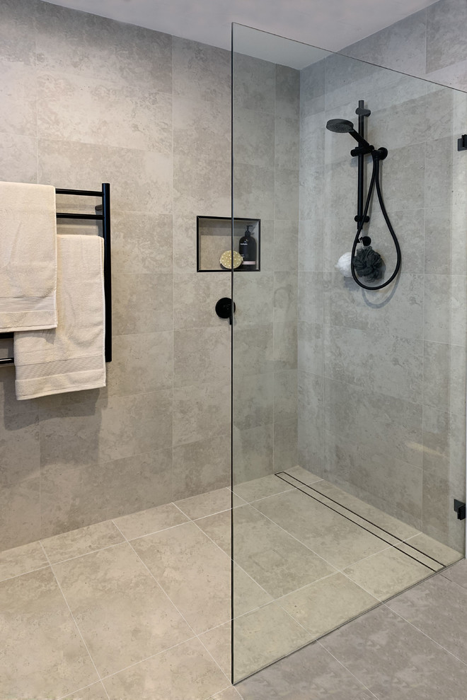 This is an example of a mid-sized contemporary master bathroom in Sydney with flat-panel cabinets, light wood cabinets, a freestanding tub, a corner shower, gray tile, ceramic tile, grey walls, ceramic floors, a vessel sink, solid surface benchtops, grey floor, an open shower and white benchtops.