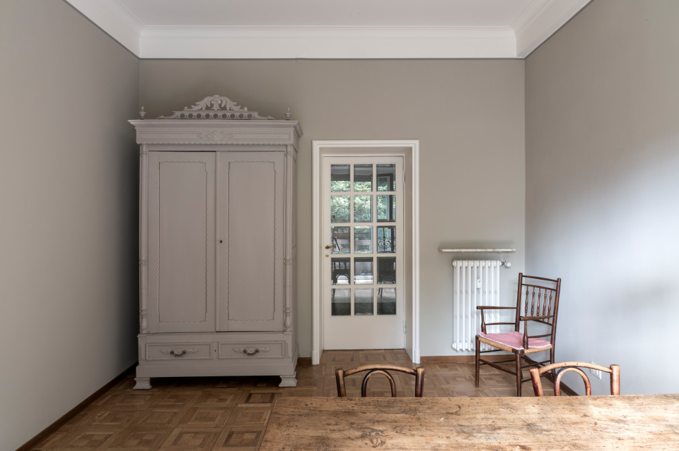 Photo of a medium sized classic craft room in Milan with grey walls, medium hardwood flooring, a freestanding desk and beige floors.