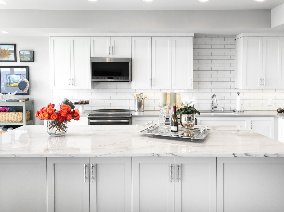 Large transitional l-shaped open concept kitchen photo with an undermount sink, subway tile backsplash, stainless steel appliances and an island