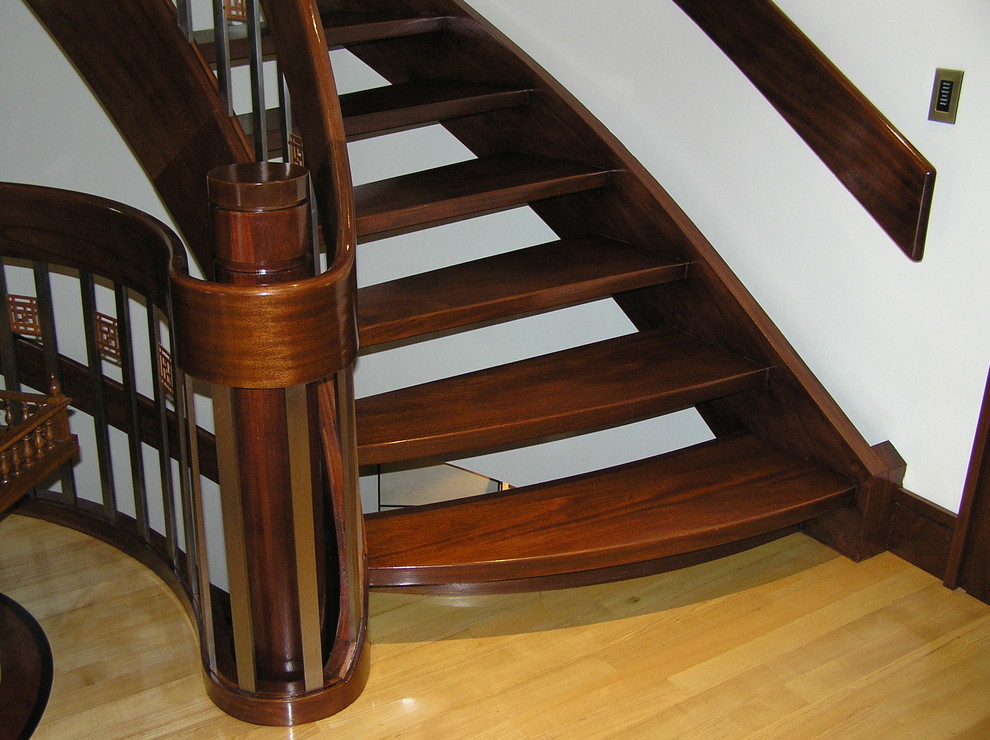 Photo of a large asian wood curved staircase in Burlington with open risers.