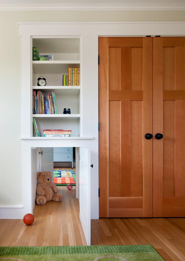 Photo of a traditional gender-neutral kids' room in Boston with light hardwood floors and yellow walls.