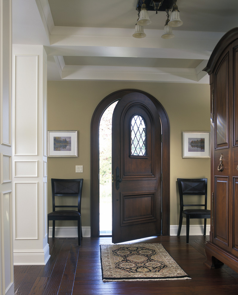 Large traditional entryway in Grand Rapids with beige walls, dark hardwood floors, a single front door and a dark wood front door.