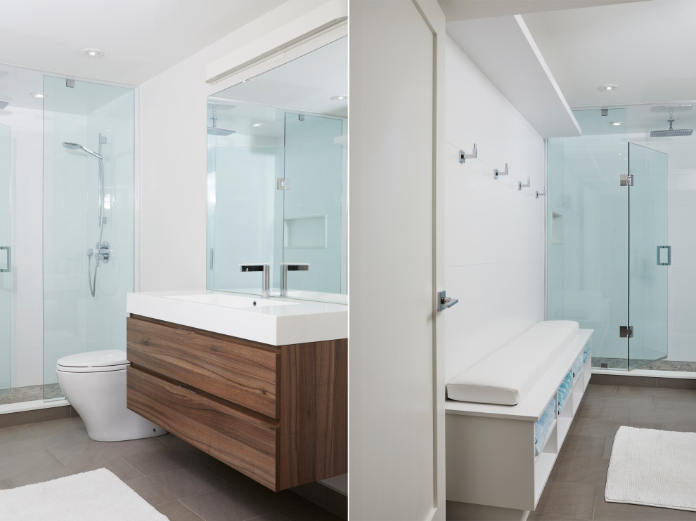 This is an example of a mid-sized contemporary bathroom in Toronto with flat-panel cabinets, medium wood cabinets, a wall-mount toilet, black tile, mirror tile, white walls, medium hardwood floors, a vessel sink, laminate benchtops, brown floor and grey benchtops.