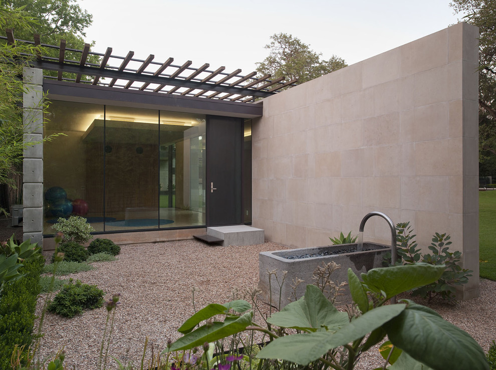 Design ideas for a mid-sized modern backyard shaded garden in Austin with a water feature and gravel.