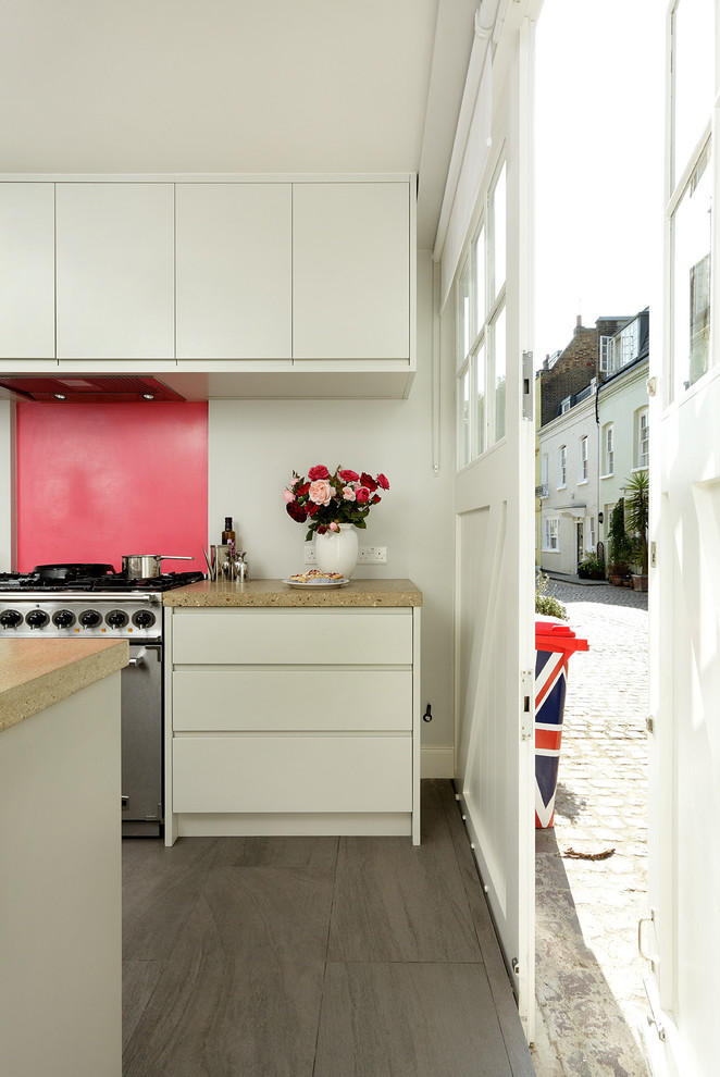 Photo of a contemporary single-wall open plan kitchen in London with flat-panel cabinets, grey cabinets, concrete benchtops, pink splashback, panelled appliances, porcelain floors and with island.
