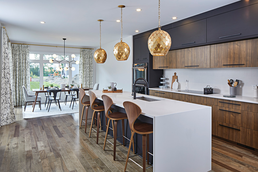 Photo of a mid-sized contemporary l-shaped eat-in kitchen in Ottawa with an undermount sink, flat-panel cabinets, black cabinets, granite benchtops, ceramic splashback, stainless steel appliances, with island, brown floor, white splashback and medium hardwood floors.
