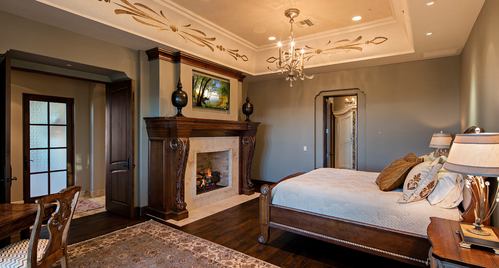 This is an example of a mid-sized traditional master bedroom in Phoenix with grey walls, dark hardwood floors, a standard fireplace and a stone fireplace surround.