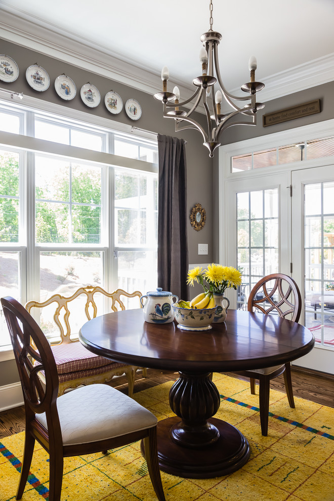 This is an example of a traditional dining room in Raleigh with grey walls and medium hardwood floors.
