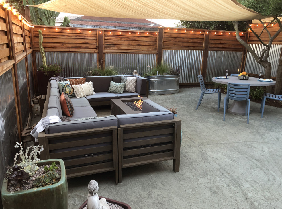 Mid-sized industrial backyard full sun xeriscape in San Francisco with a fire feature and gravel.