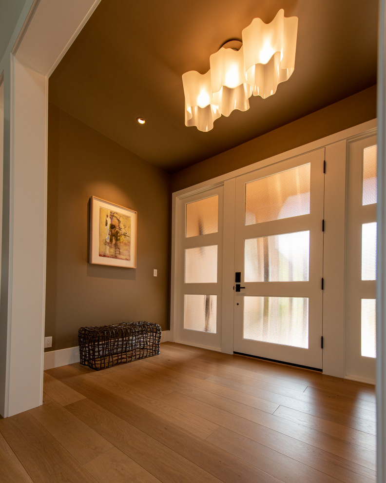 Photo of an expansive country foyer in San Francisco with brown walls, light hardwood floors, a single front door, a white front door, yellow floor and exposed beam.