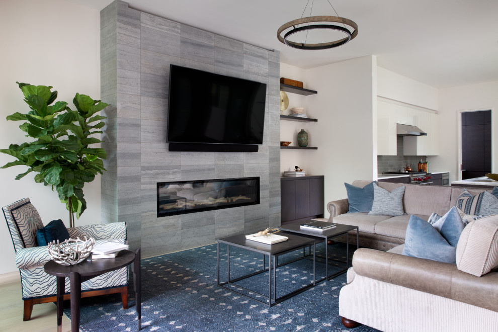 Photo of a mid-sized contemporary formal open concept living room in Austin with beige walls, medium hardwood floors, a standard fireplace, a metal fireplace surround and a wall-mounted tv.