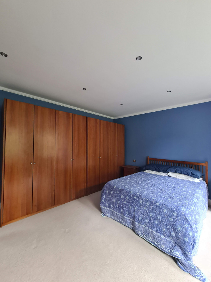 Cette photo montre une très grande chambre chic avec un mur bleu, un sol beige et un plafond décaissé.