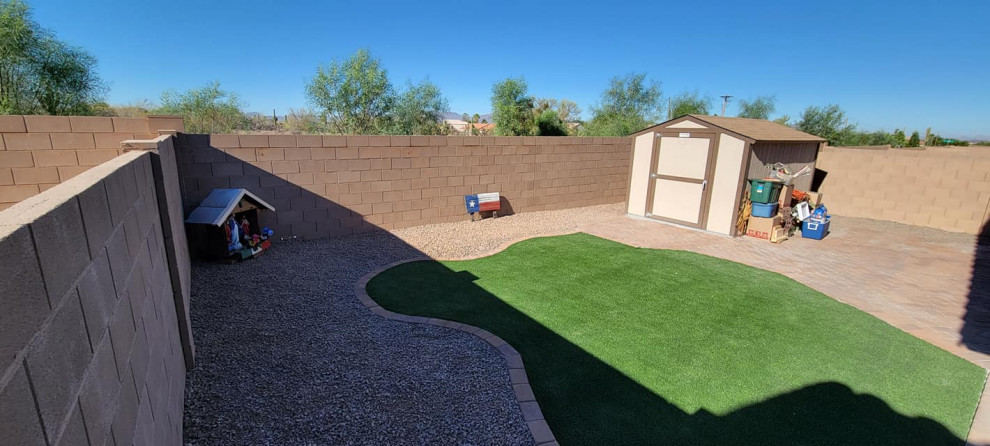 Immagine di un giardino xeriscape stile americano esposto in pieno sole dietro casa con un focolare, sassi e rocce, pavimentazioni in mattoni e recinzione in pietra