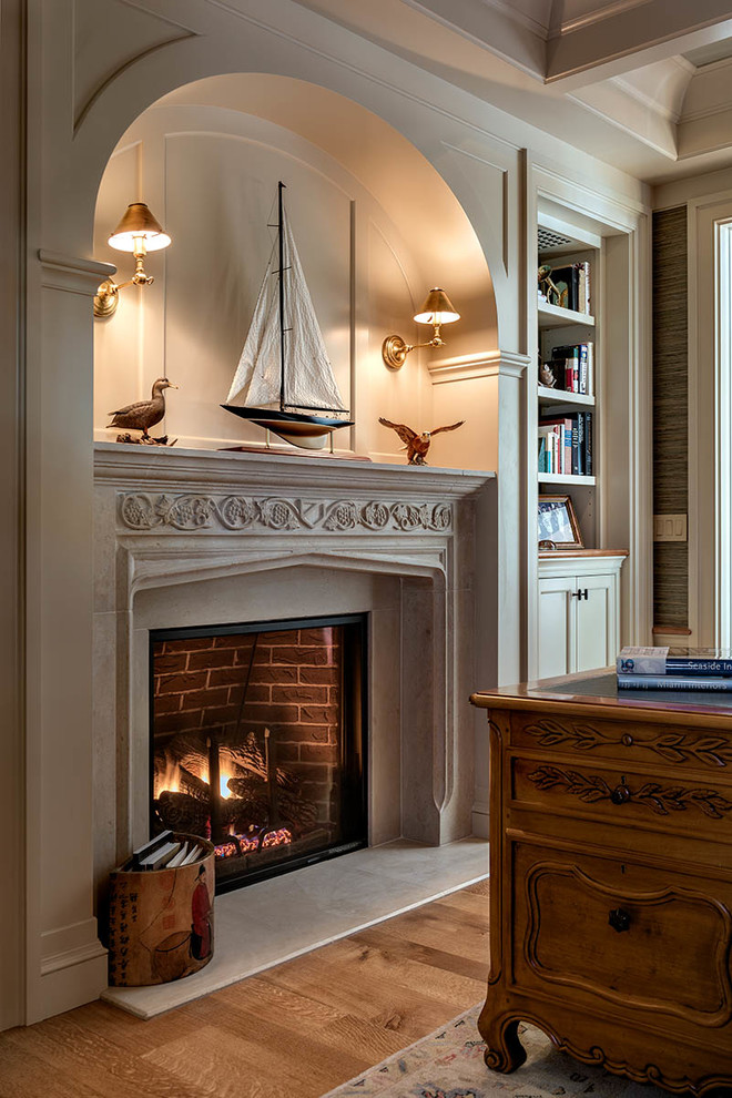 Inspiration for a traditional study room in Other with a standard fireplace, a wood fireplace surround and a freestanding desk.