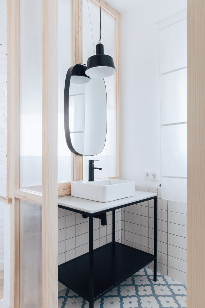 Photo of a small industrial cloakroom in Valencia with white cabinets, a one-piece toilet, white tiles, ceramic tiles, white walls, ceramic flooring, a vessel sink, marble worktops, blue floors, white worktops and a built in vanity unit.